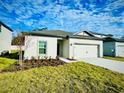 New construction home with a two-car garage, freshly landscaped at 13469 Leaping Water Way, Astatula, FL 34705