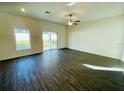 Spacious living room with dark hardwood floors and sliding doors at 13485 Leaping Water Way, Astatula, FL 34705