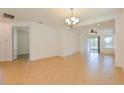 Dining area with tile flooring, chandelier, and adjacent living room space at 1423 Harbor Ridge Dr, Poinciana, FL 34759