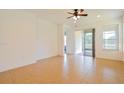 Open living area with tile flooring, ceiling fan, and sliding glass door to patio at 1423 Harbor Ridge Dr, Poinciana, FL 34759