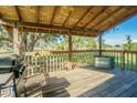 Back porch with wooden flooring, grill, and a water tank at 16 Ridge Rd, Frostproof, FL 33843