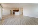 View of the open living area with wood-look flooring, showing the adjacent kitchen and dining space at 5638 Cedar Waxwing Dr, The Villages, FL 32163