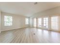 Spacious living room with wood-look flooring and large windows providing ample natural light at 5638 Cedar Waxwing Dr, The Villages, FL 32163