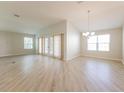 Open-concept living and dining area with vaulted ceilings and sliding glass doors at 5638 Cedar Waxwing Dr, The Villages, FL 32163