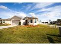 Tan house with a two-car garage and well-manicured lawn at 1046 Roberta Rd, Lake Wales, FL 33853