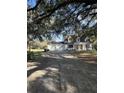 House with a long driveway, three-car garage, and landscaping at 6611 Hereford Dr, Lakeland, FL 33810