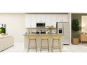 Open kitchen with white cabinets and breakfast bar at 7009 Rosy Sky Ave, Orlando, FL 32829