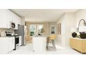 Modern kitchen with white cabinets, island, and stainless steel appliances at 7013 Rosy Sky Ave, Orlando, FL 32829