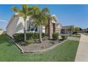 Side view of a home featuring stone accents, blue shutters, and a two-car garage at 1767 Bee Nice Dr, Kissimmee, FL 34744