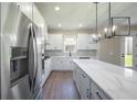 Modern kitchen featuring white cabinets, stainless steel appliances, and an island with quartz countertops at 7861 Somersworth Dr, Kissimmee, FL 34747