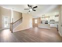 Open-concept living area with wood-look flooring, a staircase with wrought iron railing, and view of the kitchen at 7861 Somersworth Dr, Kissimmee, FL 34747