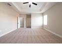 Spacious main bedroom with plush carpeting, tray ceiling, and an ensuite bathroom at 7861 Somersworth Dr, Kissimmee, FL 34747