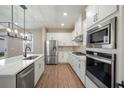 Modern white kitchen featuring stainless steel appliances, quartz countertops, and a stylish island at 7757 Somersworth Dr, Kissimmee, FL 34747