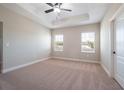 Spacious bedroom with plush carpeting, neutral-toned walls, and two large windows at 7853 Somersworth Dr, Kissimmee, FL 34747
