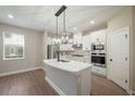 Modern kitchen featuring white cabinetry, stainless steel appliances, and a large island with quartz countertops at 7853 Somersworth Dr, Kissimmee, FL 34747