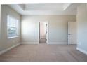 Spacious main bedroom with plush carpeting and an ensuite bathroom at 7865 Somersworth Dr, Kissimmee, FL 34747