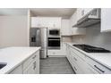 Modern kitchen with white cabinets, stainless steel appliances, and quartz countertops at 7752 Somersworth Dr, Kissimmee, FL 34747