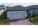 Gray house with paver driveway and landscaping; two-car garage at 4407 Rapallo Ave, Winter Haven, FL 33884