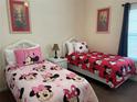 ' bedroom with two twin beds, Minnie Mouse theme, and neutral walls at 409 Lucaya Loop # 409, Davenport, FL 33897