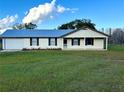 Ranch style home features metal roof, covered porch, and large yard at 4915 Mount Pleasant Rd, Groveland, FL 34736