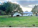 Back of house showing large oak tree and fenced yard at 4915 Mount Pleasant Rd, Groveland, FL 34736