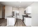 Modern kitchen with island, white cabinets, and gray countertops at 1106 Foreshore Ln, Haines City, FL 33844