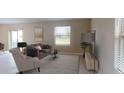 Living room with beige sofa, armchair, coffee table, and large window at 2896 Transformation Way, Clermont, FL 34714