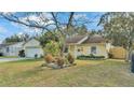 Cute yellow house with a well-maintained lawn and garden at 136 Cory Ct, Auburndale, FL 33823