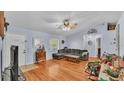 Living room featuring hardwood floors, L-shaped sofa, and a ceiling fan at 136 Cory Ct, Auburndale, FL 33823