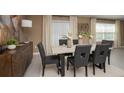 Elegant dining room with a light wood table and gray cushioned chairs at 4788 Cloister St, Kissimmee, FL 34758