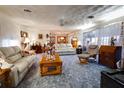 Bright living room with comfy seating, wood coffee table, and carpeted floor at 6085 Amaryllis Dr, Indian Lake Estates, FL 33855