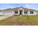 Single-story house featuring a neutral color palette and neat lawn at 840 S Palm Ave, Frostproof, FL 33843