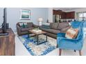 Spacious living room with gray sofas, blue armchair, and coffee table at 1534 Carey Palm Cir, Kissimmee, FL 34747