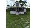 Front view of A-frame home with a screened porch at 11390 E Irlo Bronson Memorial Hwy, St Cloud, FL 34773