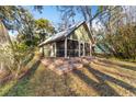 Cottage exterior features metal roof and screened porch at 10801 Sw 185Th Ter, Dunnellon, FL 34432