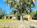 Ranch home with mature landscaping and large oak tree at 250 W New York Ave, Orange City, FL 32763