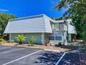 Condo building exterior with parking and tropical landscaping at 4150 S Atlantic Ave # 107C, New Smyrna Beach, FL 32169