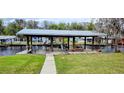 Covered waterfront dock with seating and a view of the canal at 1628 Paradise Ln, Astor, FL 32102