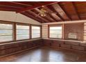 Bright sunroom with wood floors, built-in shelving, and large windows at 150 E Washington Ave, Lake Helen, FL 32744