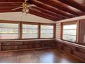 Bright sunroom with wood floors, built-in shelving, and large windows at 150 E Washington Ave, Lake Helen, FL 32744