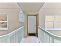 Condo entryway with light teal railings and white door at 4 Oceans West Blvd # 208C, Daytona Beach Shores, FL 32118