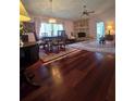 Spacious living room with hardwood floors, stone fireplace, and ample natural light at 833 E 22Nd Ave, New Smyrna Beach, FL 32169