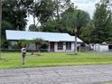 Single story home with metal roof and fenced yard at 24008 Ermine Rd, Astor, FL 32102