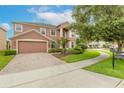 Two story house with brick driveway and landscaped yard at 206 Laurel Point Ct, Deland, FL 32724