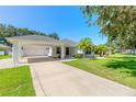 Front view of a single-story house with a carport and a palm tree at 4088 Clock Tower Dr, Port Orange, FL 32129