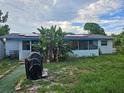 Home's backyard with grill and tropical plants at 401 Cherry St, South Daytona, FL 32119