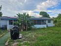 Home's backyard with grill and tropical plants at 401 Cherry St, South Daytona, FL 32119