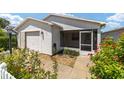 Front view of a single-story home with a screened porch at 1106 Carvello Dr, The Villages, FL 32162