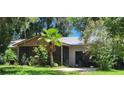 House exterior showcasing a screened porch and tropical landscaping at 711 Sunset Ave, Orange City, FL 32763