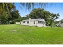 Large grassy backyard with mature trees and a detached building at 409 W Beresford Ave, Deland, FL 32720